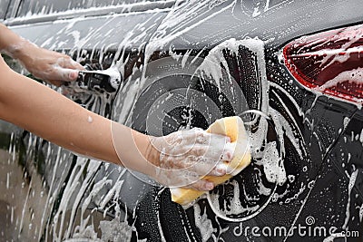 Asian hand holds sponge with car wash To clear the sides of the Stock Photo