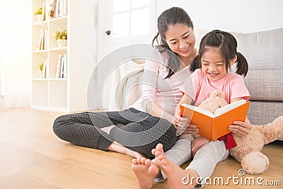 Asian happy girl holding teddy bear watching comic Stock Photo