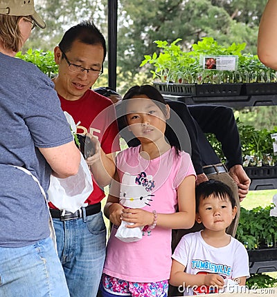 Asian heritage father with daughter and son buys plants at garden show Tulsa Oklahoma USA 4 13 2018 Editorial Stock Photo