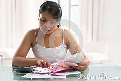 Asian housewife checking all the bills Stock Photo