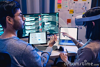 asian and Indian Developer devops team testing virtual reality coding promgram app at night in office Stock Photo