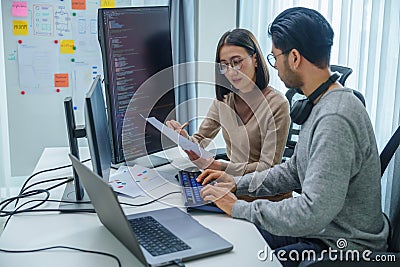 asian and Indian Developer team discussion feedback analysis coding data with software computer at office Stock Photo
