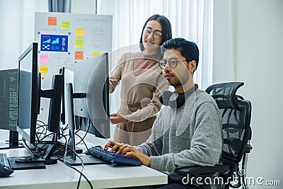 asian and Indian Developer team discussion feedback analysis coding data with software computer at office Stock Photo