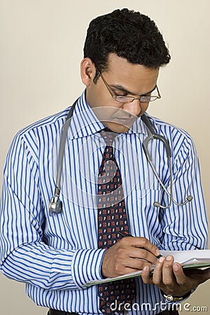 Asian Indian Doctor writing a report Stock Photo