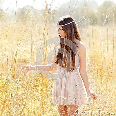 Asian indian woman walking in golden dried field Stock Photo