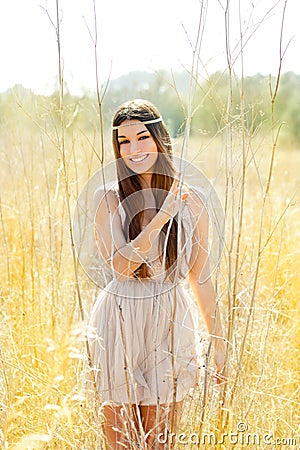 Asian indian woman walking in golden dried field Stock Photo