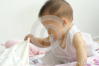 Asian infant finding item under a blanket. Stock Photo