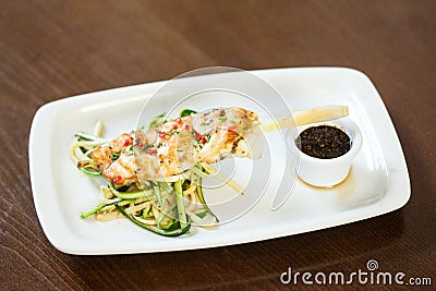 Asian inspired fish dish with noodles and julienne vegetables Stock Photo