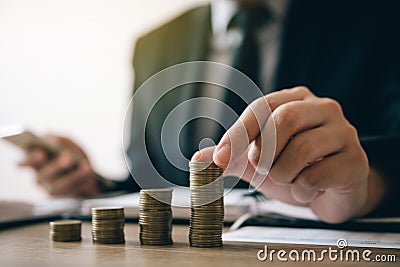 Asian investors man are placing coins in a growing position with savings finance money concept Stock Photo