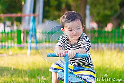 Asian kid riding seesaw board at the playground Stock Photo