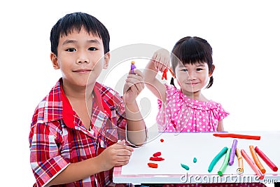 Asian kids playing with play clay on table. Strengthen the imagination Stock Photo