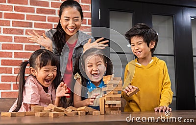 Asian Kids and their teacher are playing wooden block stack game Stock Photo
