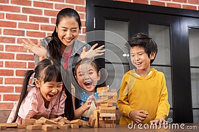 Asian Kids and their teacher are playing wooden blocks stack gam Stock Photo