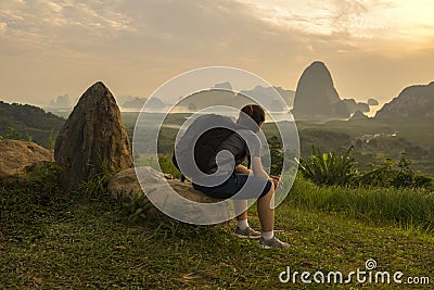 Asian lady with black bag sit on rock look at mountain and river view Stock Photo