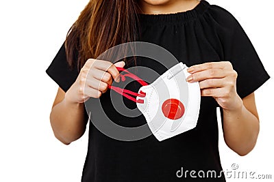 Asian lady holding face mask focus in front view with white plain background. Young lady showing face mask for use to helps protec Stock Photo