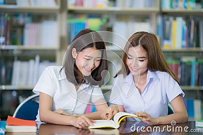 Asian lady student study and do home work in library in University Stock Photo
