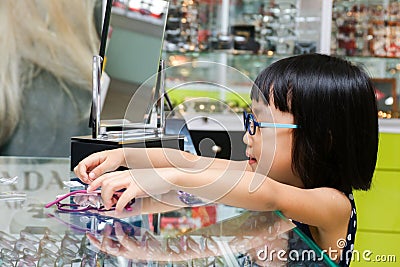 Asian Little Chinese Girl Choosing Glasses Stock Photo