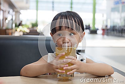 Asian little Chinese girl drinking lemon tea Stock Photo