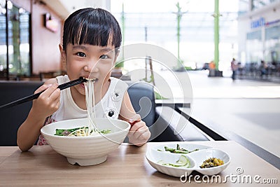 Asian little Chinese girl eating beef noodles soup Stock Photo