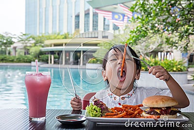 Asian Little Chinese Girl Eating Burger and French fries Stock Photo
