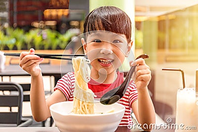 Asian little Chinese girl eating noodles soup Stock Photo