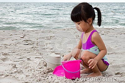 Asian Little Chinese Girl Playing Sand with Beach Toys Stock Photo