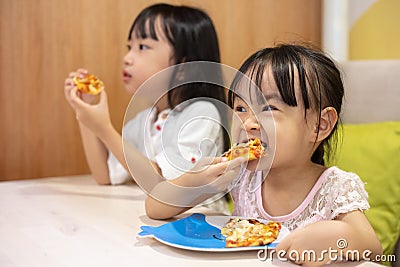 Asian Little Chinese sisters Eating pizza Stock Photo