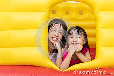 Asian Little Chinese sisters playing at inflatable castle Stock Photo