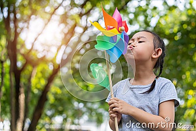 Asian little girl playing with paper windmill Stock Photo