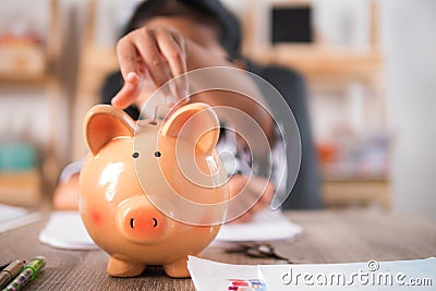 Asian little girl in putting coin in to piggy bank shallow depth Stock Photo