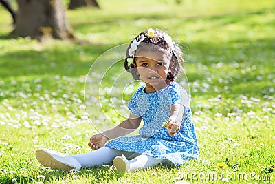 A asian little girl siting on green grass in park Stock Photo