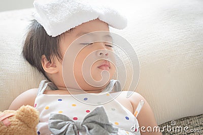 Asian little girl sleep and sick on sofa with cooler gel on her Stock Photo