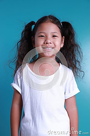 Asian little kid girl smile happiness portrait looking at the camera on green background Stock Photo