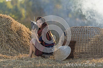 Asian local beautiful woman listening radio on straw Stock Photo