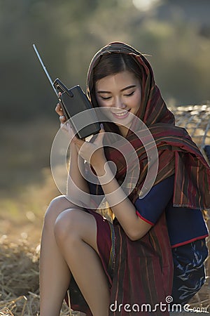 Asian local beautiful woman listening radio on straw Stock Photo