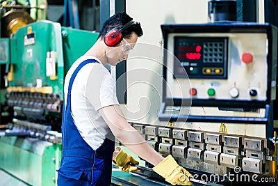 Asian machine operator in production plant Stock Photo