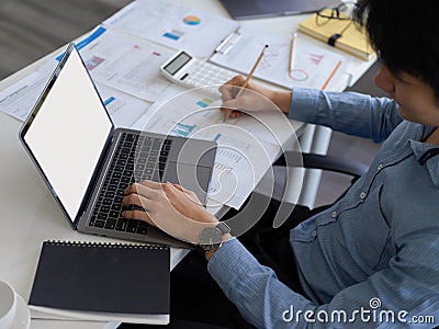 Asian male banker or broker is working on portable laptop computer Stock Photo