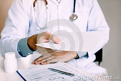 Asian male doctor handing giving a prescription to the patient Stock Photo