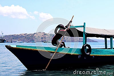 Asian male parking his boat over the sea, fisherman resting his wooden boat at the port or harbor area Editorial Stock Photo