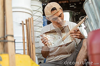 Asian male seller holding a dustpan trash when sitting on the floor Stock Photo