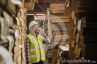 Asian male worker, supervisor talks with mobile phone at paper factory Stock Photo