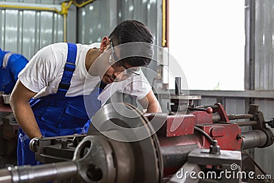 asian male workers brake disc grinder. repair and maintenance service automobile. Car auto part repair service center Stock Photo