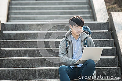 Asian man backpacking using laptop. Stock Photo