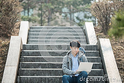 Asian man backpacking using laptop. Stock Photo