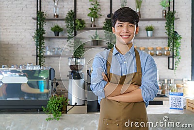 Asian man Barista or owner small business in apron looking at camera and arm crossed at the modern coffee shop Stock Photo