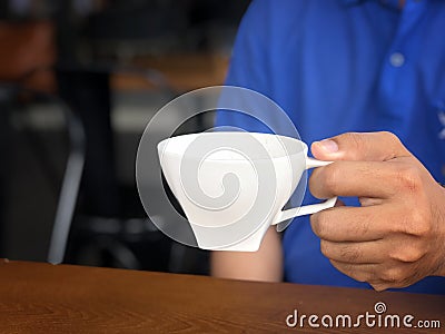 Asian man catch a glass to drink more coffee in coffee shop Stock Photo