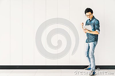 Asian man or college student using digital tablet cheering celebrate success, copy space on white wall background Stock Photo