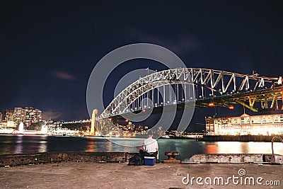 An Asian man fishing at the pier two 2, the rock at night in S Editorial Stock Photo