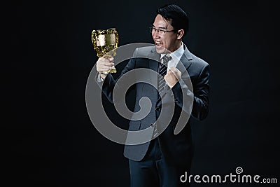 Asian man in suit happy with trophy Stock Photo