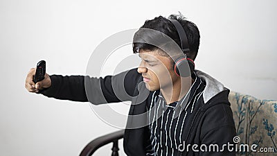 Asian man with headphone wearing black jacket holding remote while sad expression face cheering for indian team Stock Photo